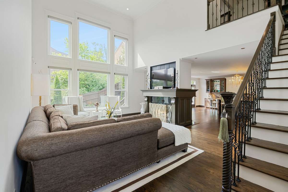 Expansive 2 story living room is light filled with a double sided fireplace.
