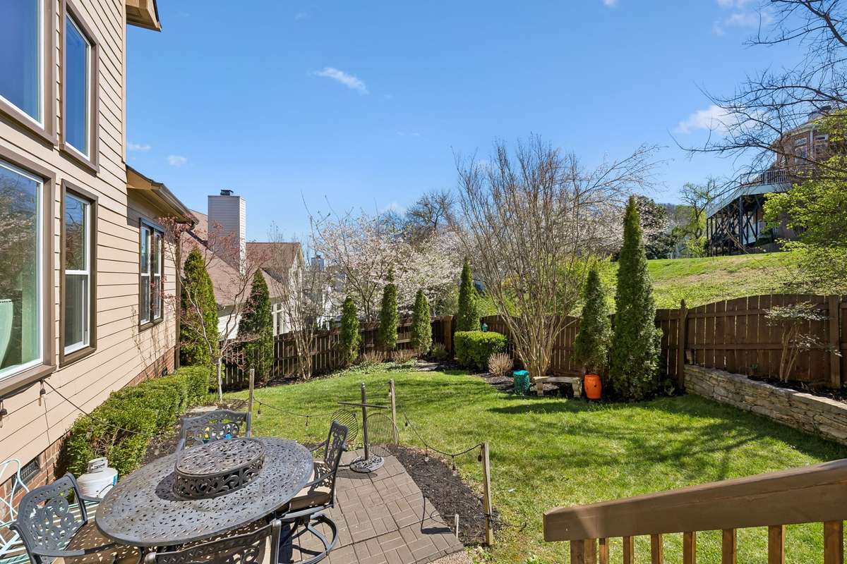Serene backyard. Lower stone paver patio painted March 2025. Mature landscaping.