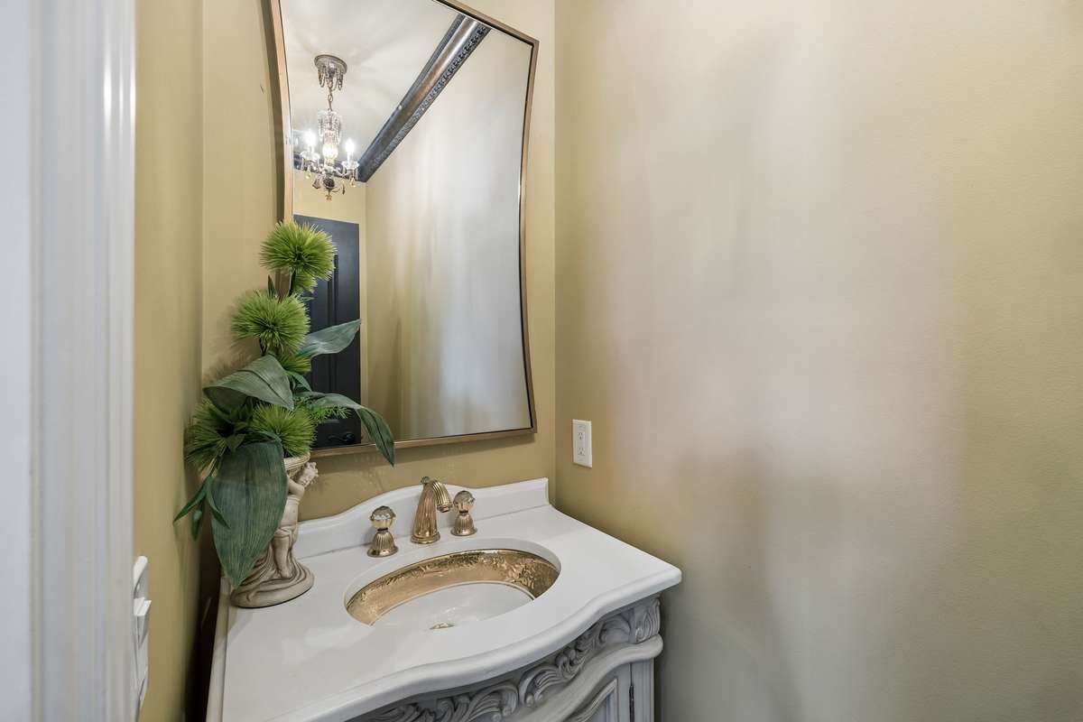 Gorgeous powder room on the first floor with antique vanity and silestone countertop.