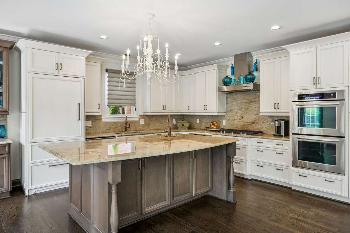 Two sinks (prep sink in island) both with Brizzo copper faucets. Cabinet depth Sub-Zero refrigerator with cabinet paneling.