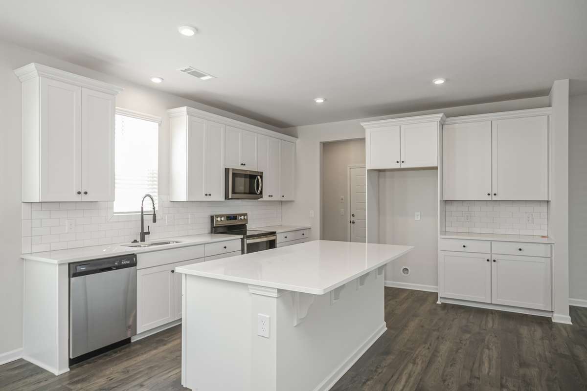 Ample storage and serving space! SS appliances, tile backsplash, and quartz countertops included in your kitchen. **All photos are of a previously constructed Covington floorplan.**