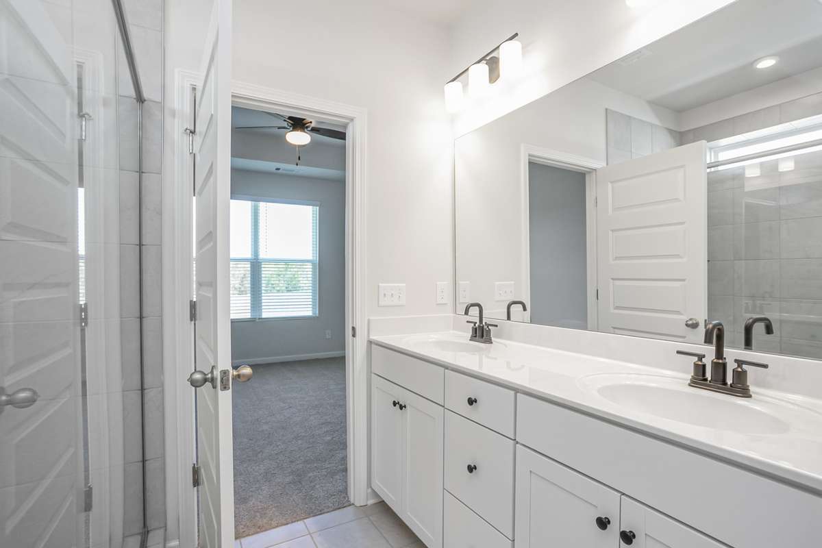 Double vanities, tile flooring, and quartz countertops in your primary suite. **All photos are of a previously constructed Covington floorplan.**