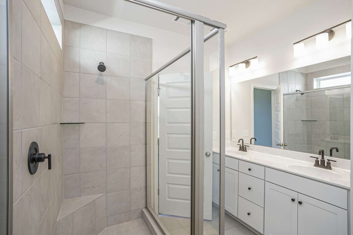 Double vanities, tile flooring, and quartz countertops in your primary suite.  **All photos are of a previously constructed Covington floorplan.**