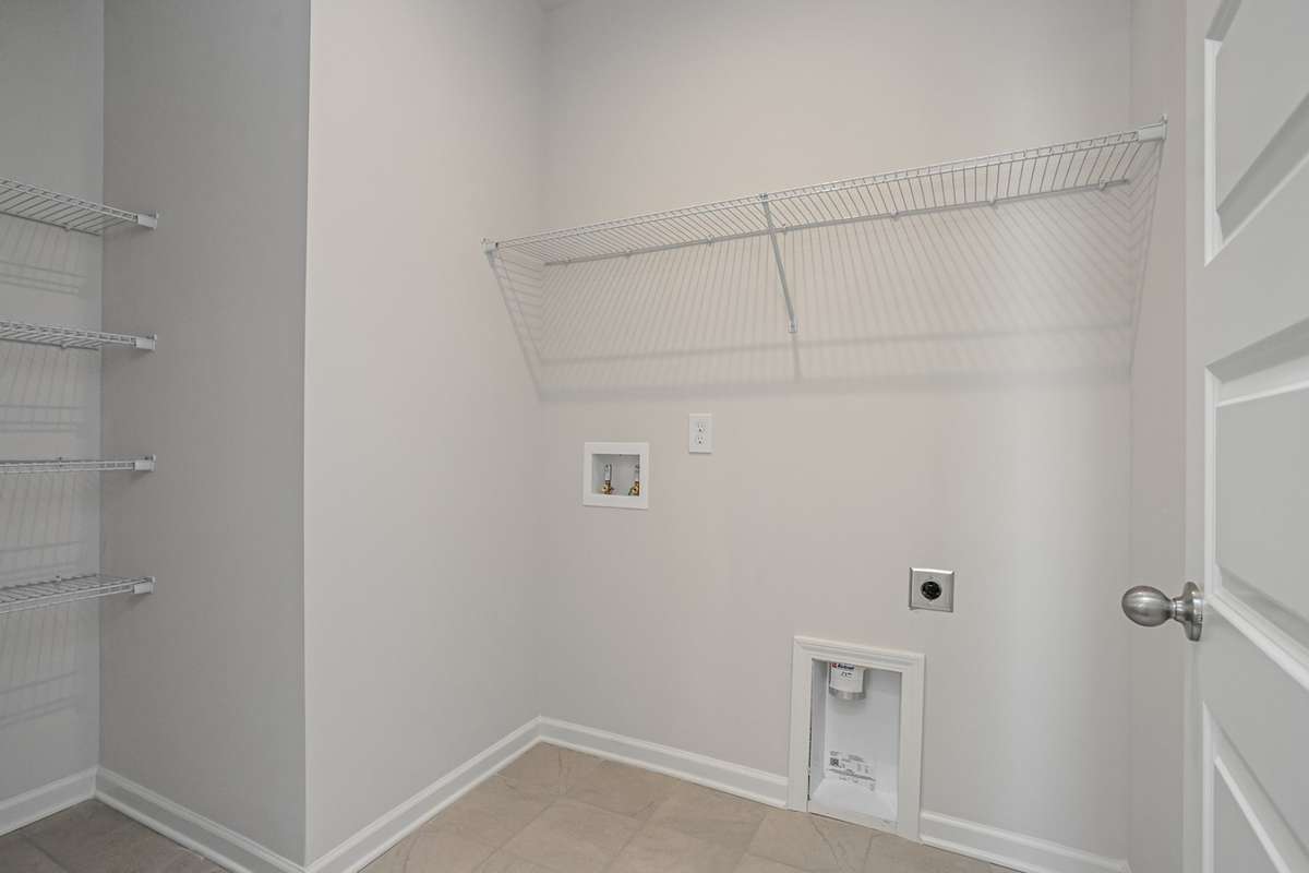 Spacious laundry with built-in linen shelving near your primary bedroom downstairs. **All photos are of a previously constructed Covington floorplan.**