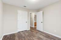 Bedroom 3 with a view into the hallway and shared full bathroom, offering easy access and a comfortable, functional layout.
