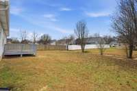 Generous, flat backyard featuring a newly rebuilt deck—perfect for outdoor entertaining, relaxing, and enjoying sunsets.