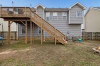 Rear elevation highlighting the split level design and deck stair access to the yard.