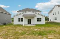 The rear view of your home showcases the covered rear patio and yard, perfect for entertaining and outdoor enjoyment.