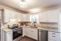 Stainless steel appliances add a modern touch while complementing the clean, timeless design of the kitchen.