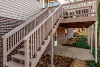 Stairs from the upper deck lead down to the lush backyard, creating a seamless connection between outdoor living spaces.