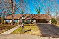 Classic ranch-style charm shines through with a low-profile roofline and a welcoming front entrance surrounded by lush greenery.