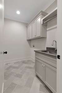 Spacious Laundry Room w/ Built In Cabinets, Drying Rack, Sink & Access to Primary Walk In Closet