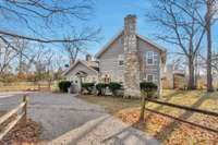 Picturesque view of the home with 2 fireplaces and their stone chimneys