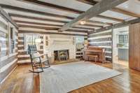 Large Living Room with beautiful 4 sided log walls, wood burning stove, and stone hearth.
