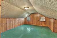 Bedroom 3 with closet and storage under the shorter knee walls.  Very cool vintage wallpaper ceiling.