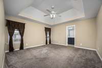 The primary bedroom is spacious with a trey ceiling, newer carpet, two windows overlooking the back yard and ceiling fan.