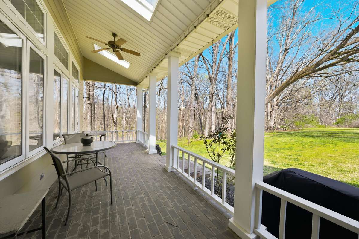 Covered Back Porch – This inviting covered porch features skylights and a ceiling fan, creating a bright and comfortable outdoor living space. Brick flooring and classic columns add charm, while the layout is perfect for relaxing or outdoor dining