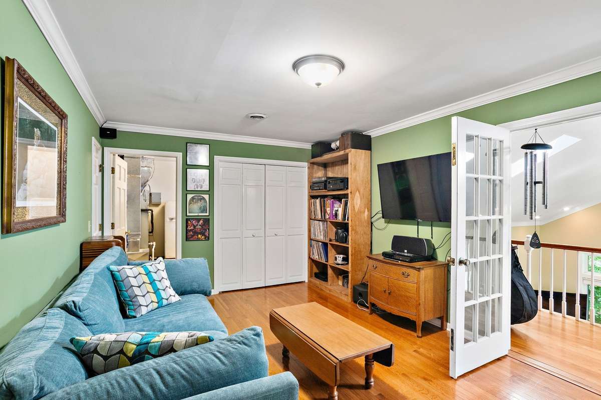 Bonus Room – Comfortable bonus room with hardwood flooring, built-in shelving, and space for media or lounging. Double doors open to the main area, creating a flexible extension of the home.