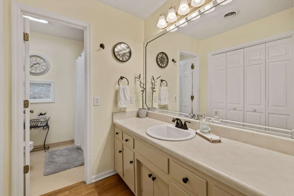 Primary Bathroom – Spacious primary bath features a long vanity with ample counter space, large mirror, and abundant storage. Neutral tones and bright lighting create a clean, functional space.