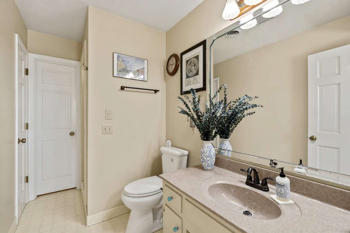 Jack-and-Jill Bathroom – Convenient shared bathroom with a spacious vanity, large mirror, and neutral finishes. Connects adjoining rooms for added functionality and ease of access.