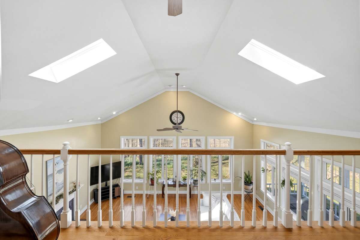 Loft/Overlook – Open loft overlooks the living room below, featuring hardwood flooring, skylights, and a railing that enhances the airy feel. Ideal as a reading nook, office, or creative space.