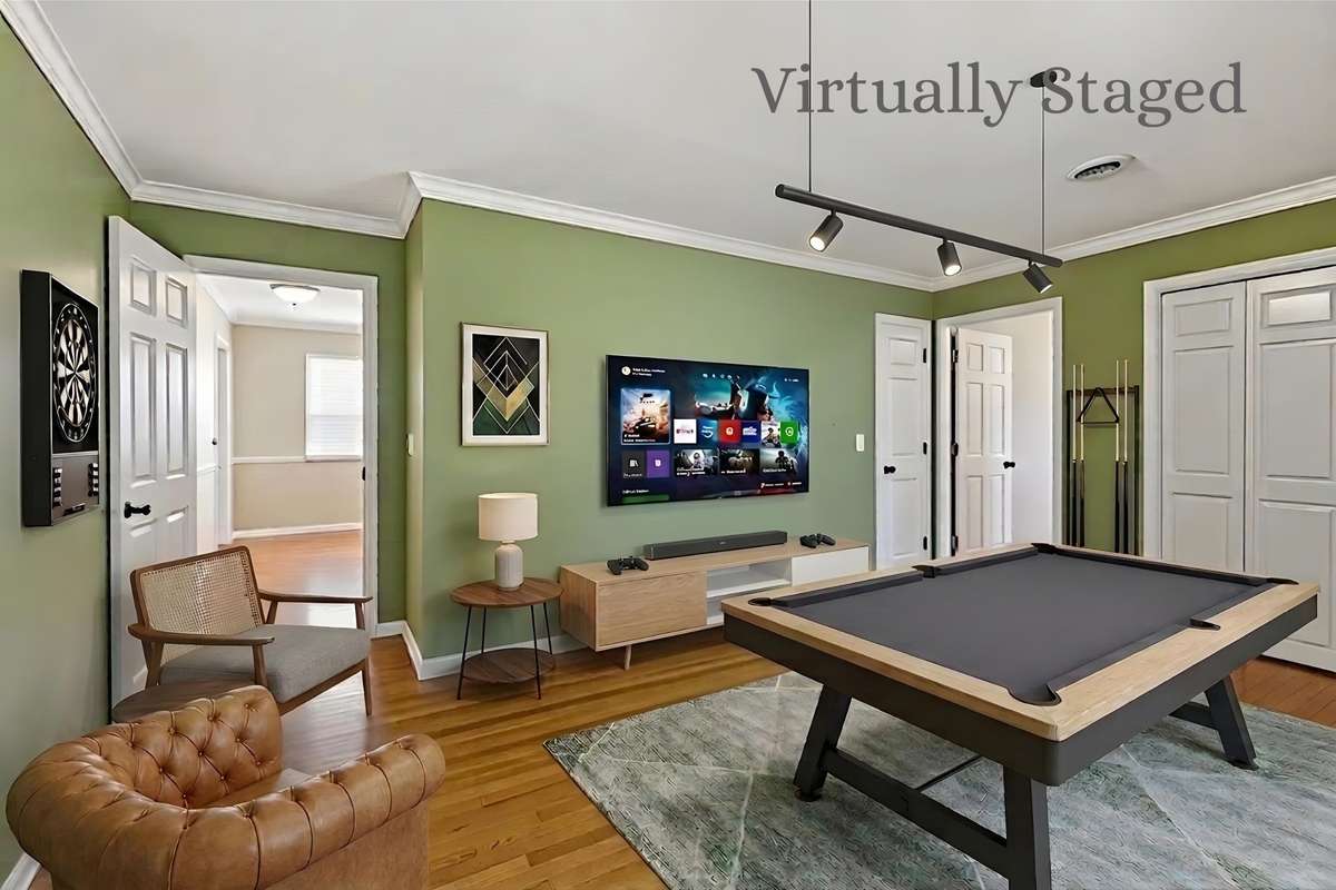 Bonus Room (Virtually Staged) – Versatile bonus space with hardwood flooring and crown molding, shown as a recreation area with room for a pool table and media setup. Ideal for a game room, home office, or additional living space