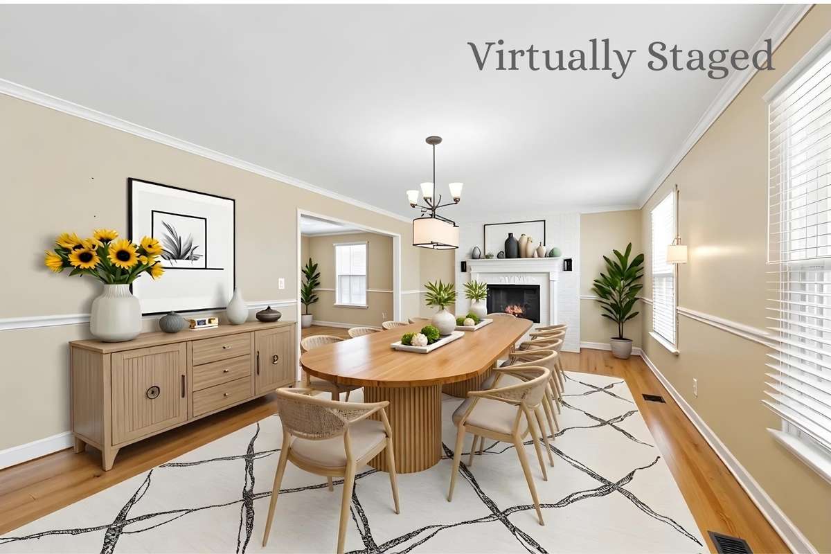 Dining Room (Virtually Staged) – Spacious dining area with hardwood flooring, chair rail detailing, and abundant natural light. Shown staged to highlight room for a large table, ideal for gatherings and entertaining.