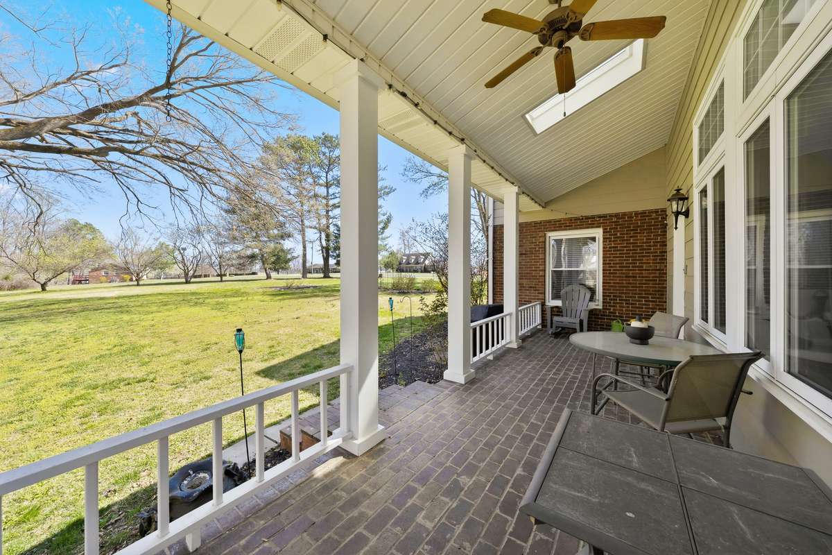 Covered Back Porch (Alternate View) – Enjoy peaceful views of the expansive backyard from this spacious porch, offering ample room for seating and entertaining. The combination of shade and natural light makes it ideal for year-round enjoyment.