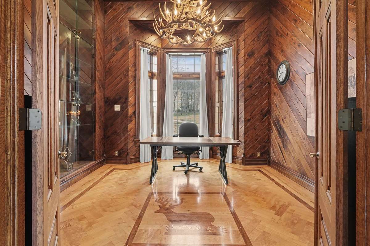 inlaid floors, floor to ceiling trophy case with large custom antler chandelier. Large picture windows