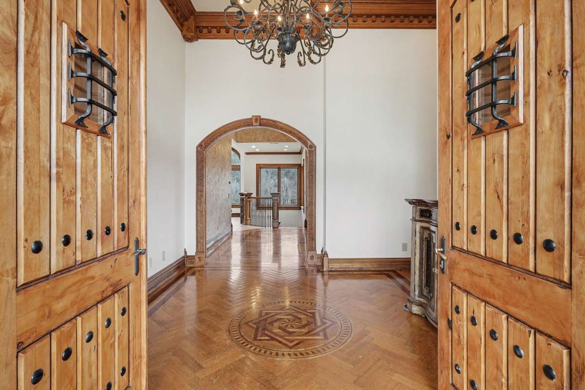 Custom designed double doors open to foyer with inlaid wood floors. Views go all the way to back of home to bluffs.