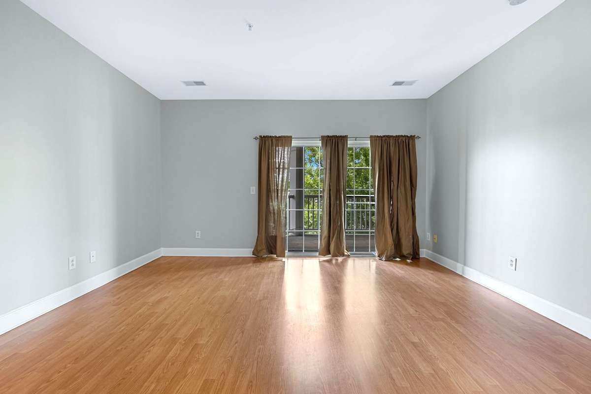 The sunlit living room (and primary suite) each open directly onto a private balcony.