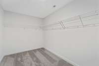 Picture of model home and not of actual home being built.  Colors, selections, and options may vary.  One of the walk in closets in Owners bedroom