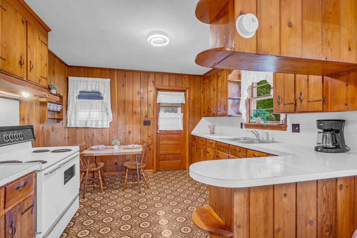 Feel right at home in this kitchen with solid wood panelling & cabinets.