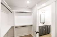 primary bath has a large walk in closet with wood shelving~