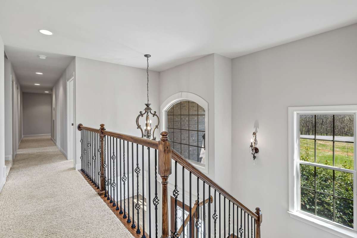 Thoughtful light fixtures are placed throughout the home to enhance its elegance. 
The beautifully designed staircase boasts wrought iron spindles and an eye-catching light fixture.