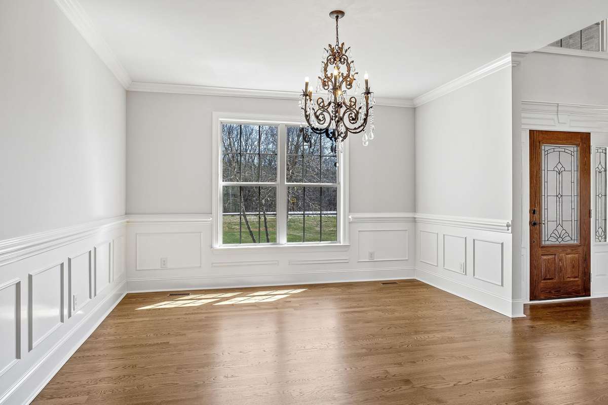 The expansive Dining Room easily accommodates large gatherings, with elegant moldings extending to the ceiling and stunning light fixture.