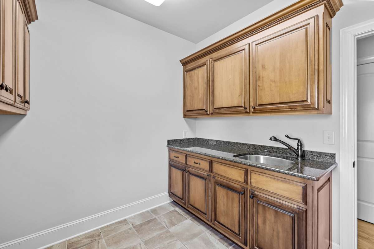 The large Utility Room with a separate sink and cabinetry provides convenient storage.
