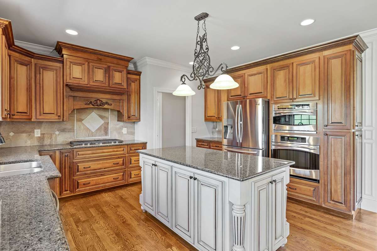The massive island creates an inviting and highly functional space. A beautiful light fixture over the super large work island.  Expertly designed Kitchen is designed for efficiency and easy care.