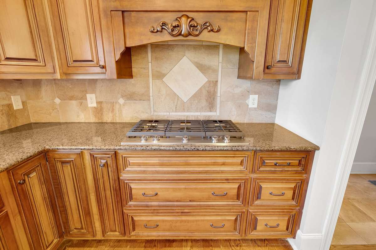 A striking, custom range hood adds to the kitchen’s appeal.