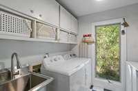 Large laundry room with folding table and utility sink - tons of storage and washer and dryer remain