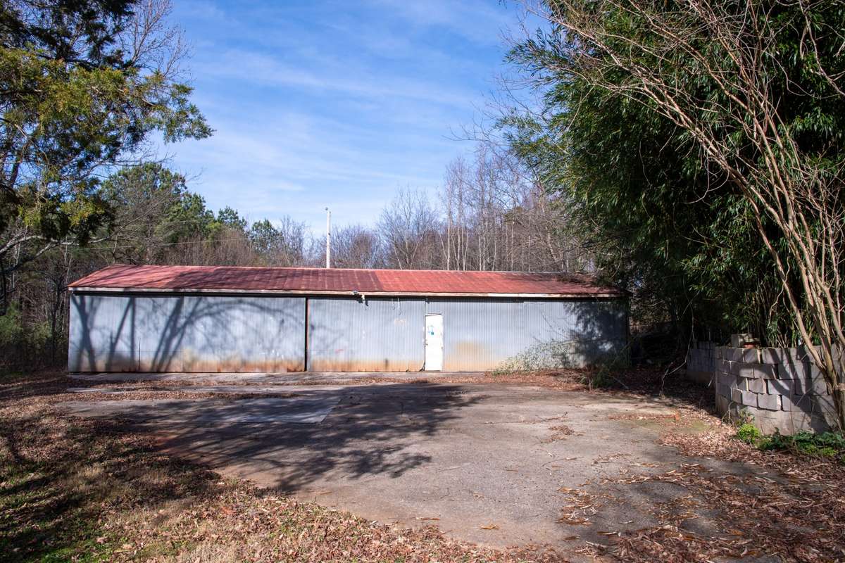 metal barn behind house with circular driveway