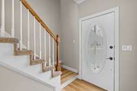 Home features two staircases one in front and one off the kitchen