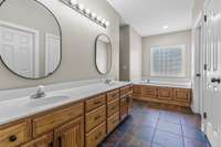 Large master bath suite with double vanities, large tub and walk in shower with tile flooring
