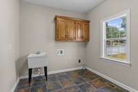 Utility room with custom cabinets and utility sink.