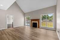 Large great room with cathedral ceiling and fireplace with gas logs