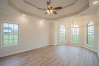 Primary Bedroom Features a Sitting Area, Double Tray Ceiling, Crown Molding and Recessed Lighting!