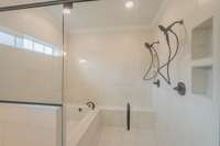 Luxurious Walk-in Tile Shower w/ 2 Shower Heads & a Garden Tub All Enclosed Behind Glass! There is also a Bench & Built-in Shelving!