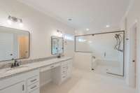 Primary Bathroom Features a Luxurious Shower, Double Vanity w/ Cosmetic Area, Private Toilet Room & Access to the Laundry Room!