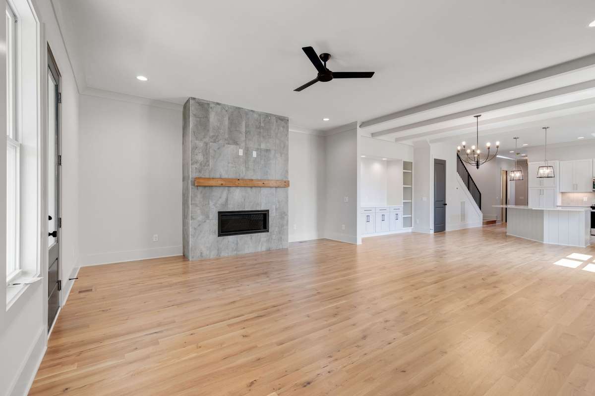 The large living room features a modern ceiling fan and abundant recessed lighting, with a fireplace as the centerpiece. 6369 Alamo Pl  Nashville, TN