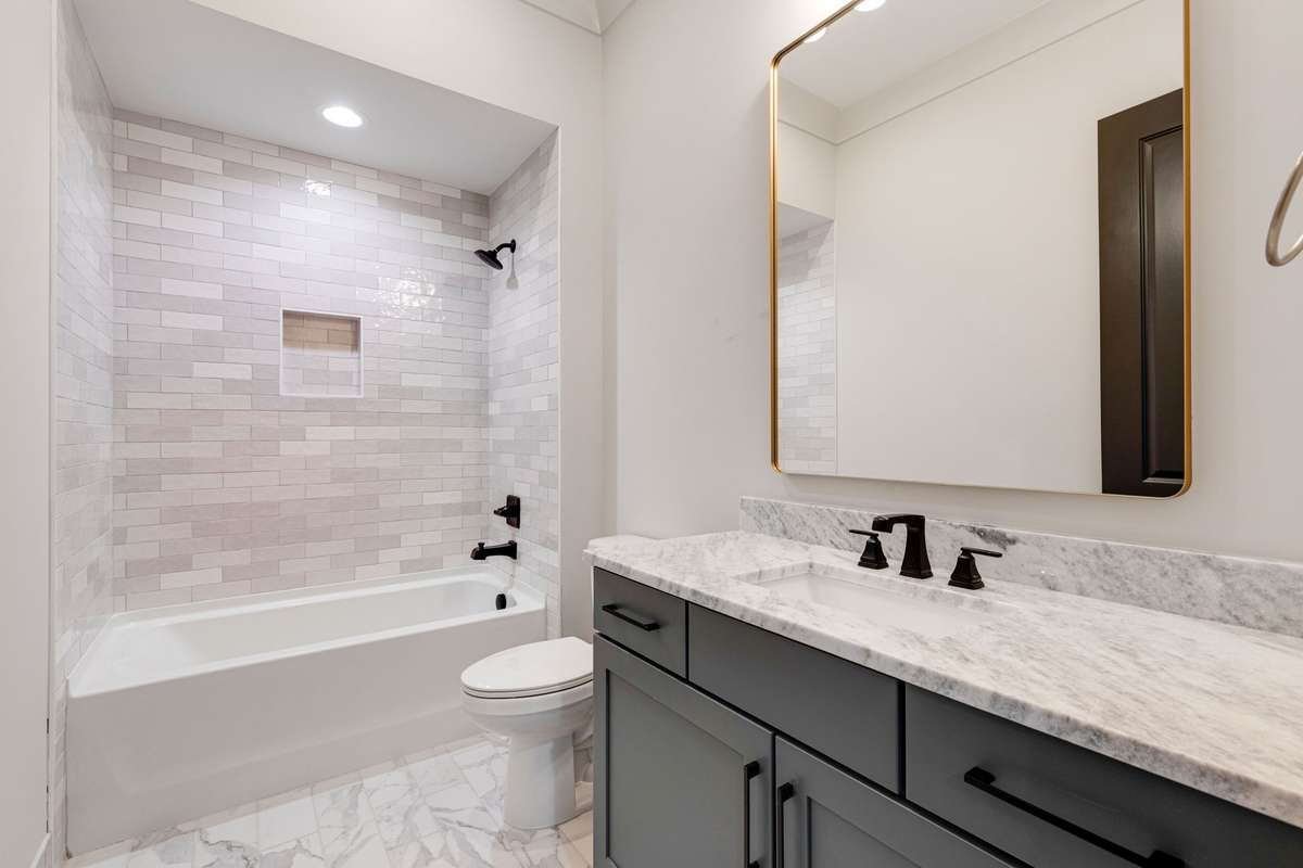 The ensuite bathroom in the third bedroom features a tiled wall for the combo shower and tub, along with a single vanity. 6369 Alamo Pl  Nashville, TN